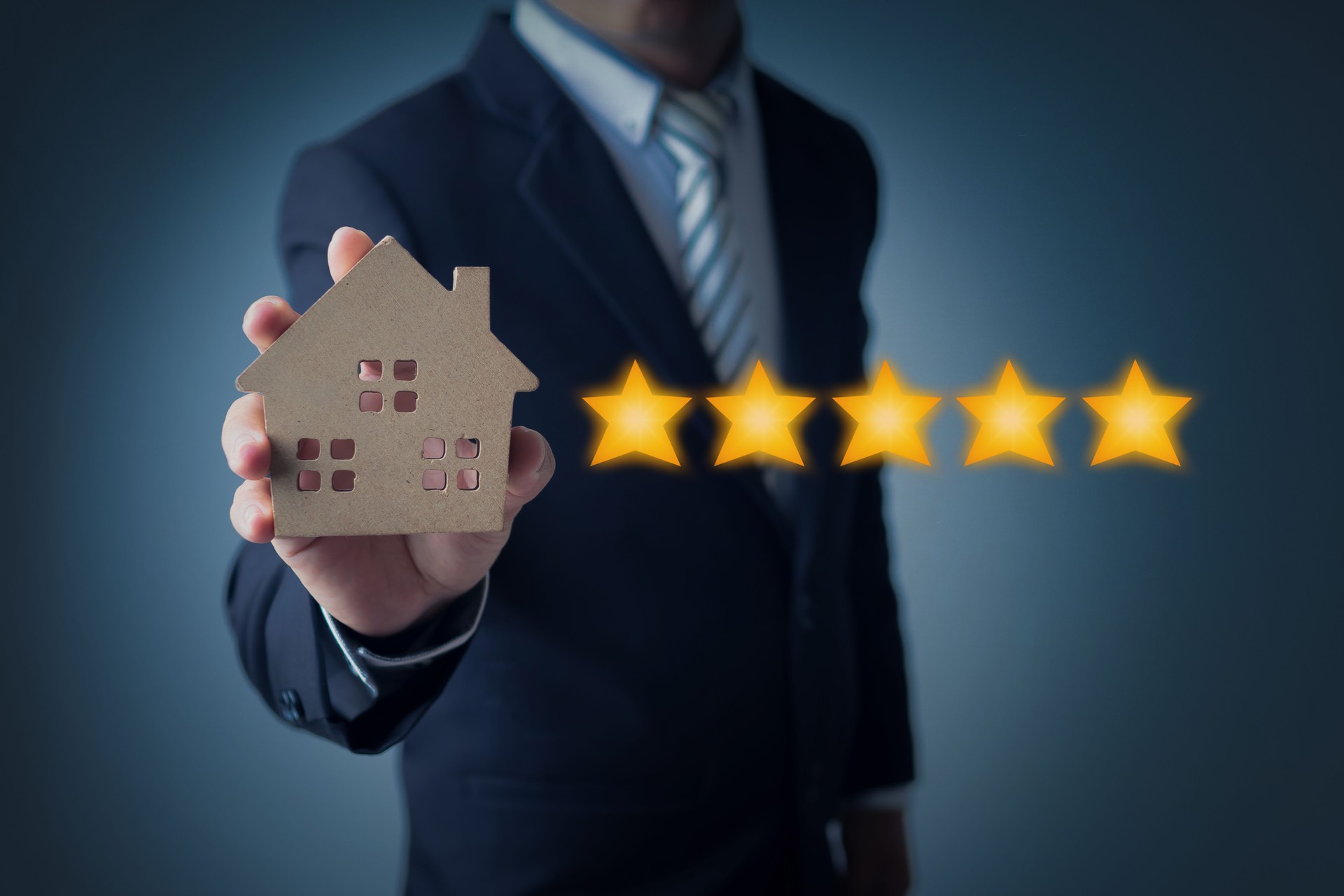 excellent service and best customer experience of real estate, business man showing 5 stars rating with wood home model on dark blue background